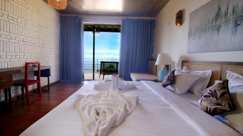 a large white bed in a room with a large window at Vantage hills Haputale in Haputale