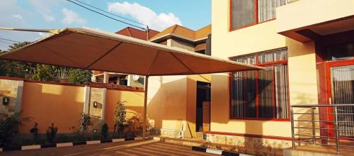 a large brown umbrella in front of a building at Ineza Apartment in Kigali