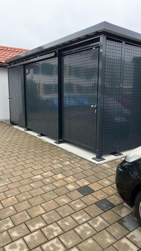 a black fence on a building with a car at Traumwohnung Füssen 22 in Füssen