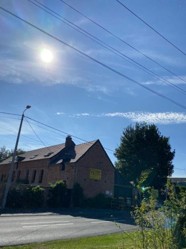 a house on a street with the sun in the sky at A la campagne in Villers-Pol