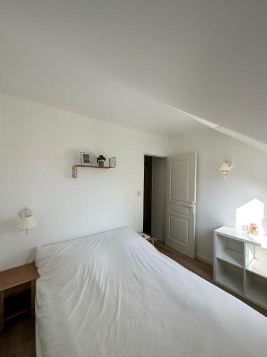 - une chambre blanche avec un grand lit blanc dans l'établissement Cottage Douillet 2 nuits minimum, à Ploemel