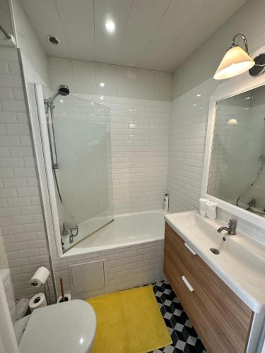 une salle de bain avec une baignoire, des toilettes et un lavabo dans l'établissement Cottage Douillet 2 nuits minimum, à Ploemel