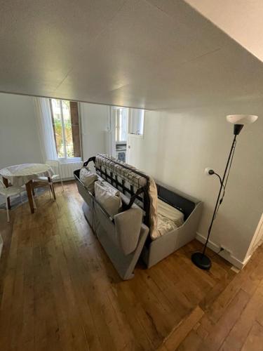 a living room with a couch and a lamp at Appartement de charme près du Stade de France in Saint-Denis