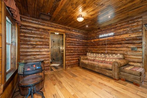 a living room with a couch in a log cabin at River Lodge Escape with Hot Tub in Glenwood