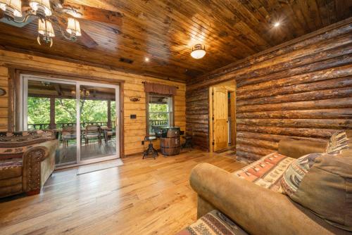 a log cabin living room with a couch and a table at River Lodge Escape with Hot Tub in Glenwood