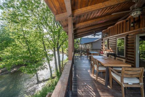 an outdoor deck with a wooden table and chairs at River Lodge Escape with Hot Tub in Glenwood