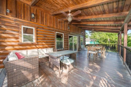 a porch of a wooden cabin with a couch and a table at River Lodge Escape with Hot Tub in Glenwood