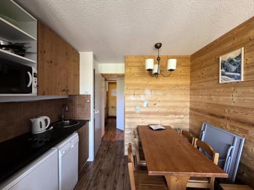 une cuisine avec une table en bois et une salle à manger dans l'établissement Résidence Themis - Studio pour 4 Personnes 35, à Mâcot La Plagne