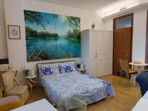 a bedroom with a bed and a painting on the wall at Appartamento luminoso Crema - parcheggio gratis in Crema