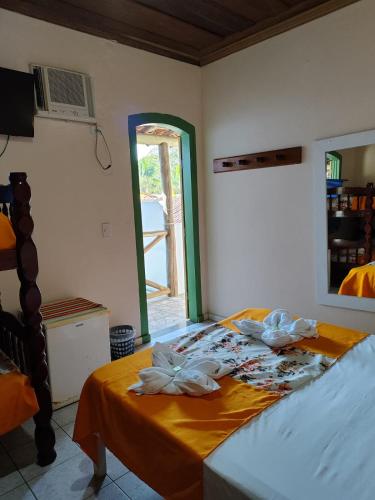 a bedroom with a bed with towels on it at Pousada Florescer in Paraty