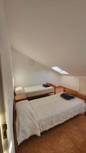 two beds in a room with a attic at Lugar das estrelas in Porriño