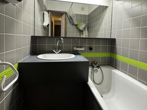 une salle de bain avec un lavabo et une baignoire dans l'établissement Résidence Carene - 2 Pièces pour 4 Personnes 23, à Mâcot La Plagne