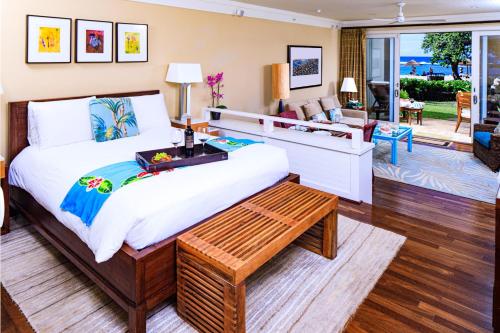 a bedroom with a large bed and a living room at Villa 102 at Turtle Bay in Kahuku