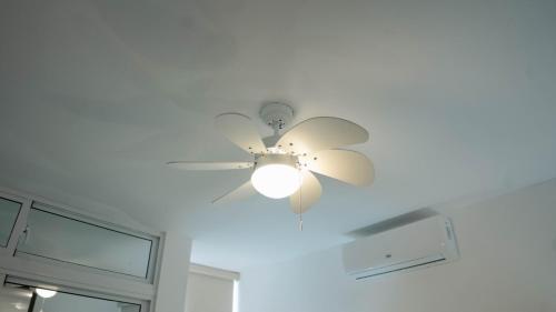 a ceiling fan with a light on a room at Residenciales H1 & H2 - Breakfast & Room Service - Airport close in Santiago de los Caballeros