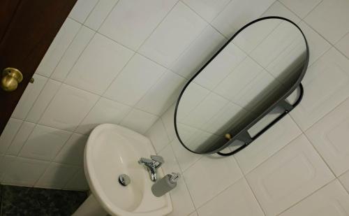 a bathroom with a sink and a mirror on the wall at Residenciales H1 & H2 - Breakfast & Room Service - Airport close in Santiago de los Caballeros