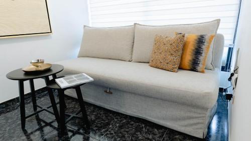 a couch in a room with a side table at Residenciales H1 & H2 - Breakfast & Room Service - Airport close in Santiago de los Caballeros