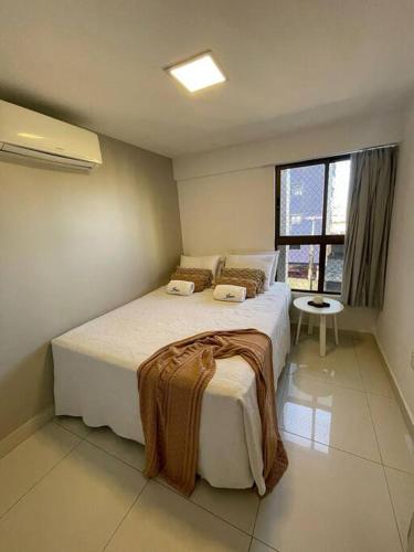 a bedroom with a large bed with a window at Urbani Smart Flat - by Jess in Tambaú