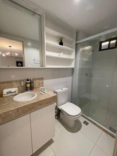 a bathroom with a toilet and a sink and a shower at Urbani Smart Flat - by Jess in Tambaú