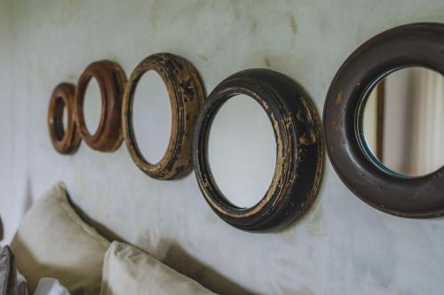 a group of mirrors hanging on a wall at The Hidden Paradise Ubud - CHSE Certified in Ubud