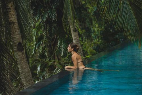 a woman sitting in a pool in the jungle at The Hidden Paradise Ubud - CHSE Certified in Ubud