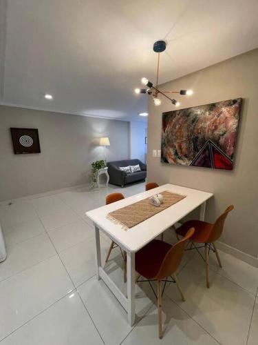 a living room with a table and chairs and a couch at Urbani Smart Flat - by Jess in Tambaú