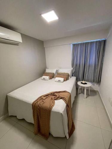 a bedroom with a large bed and a window at Urbani Smart Flat - by Jess in Tambaú