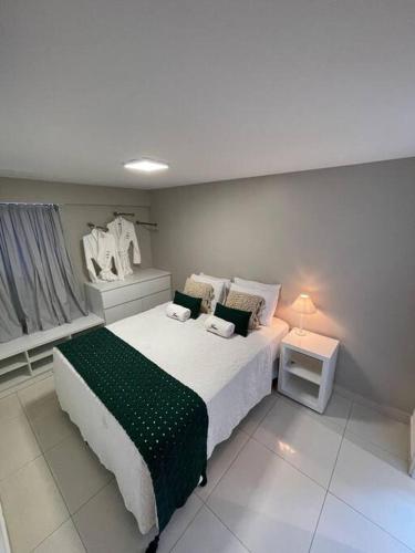 a bedroom with a large bed with a green blanket at Urbani Smart Flat - by Jess in Tambaú