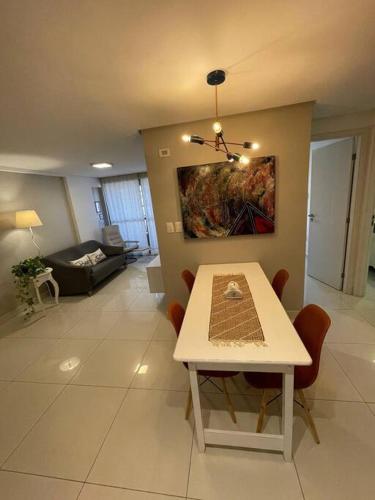 a living room with a table and a couch at Urbani Smart Flat - by Jess in Tambaú
