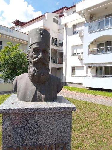 a statue of a man with a hat on his head at Tri srca in Banja Koviljača