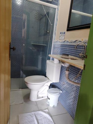 a bathroom with a toilet and a glass shower at Pousada Florescer in Paraty