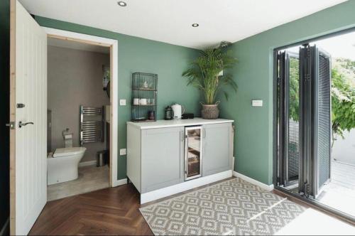 a bathroom with green walls and a bathroom with a toilet at Carden Villa 4 Bedroom House With Hot Tub Pet Friendly in Brighton & Hove
