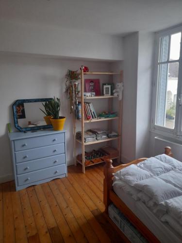 a bedroom with a bed and a dresser and a window at Maison avec jardin près de Beauval in Villentrois