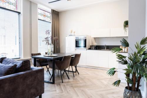 a kitchen and living room with a table and chairs at XXL loft with bath located Stadsvilla in Tilburg