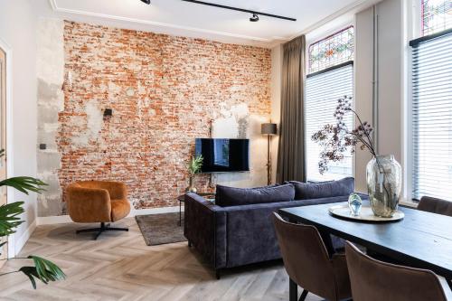 a living room with a brick wall and a table at XXL loft with bath located Stadsvilla in Tilburg