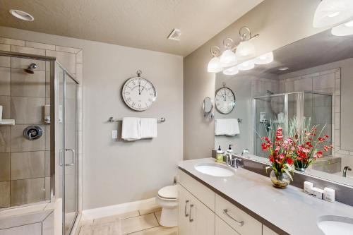 a bathroom with two sinks and two clocks on the wall at Great Escape in Washington