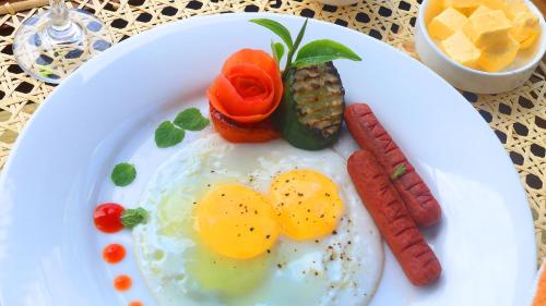 a plate of eggs and sausage on a table at Vantage hills Haputale in Haputale