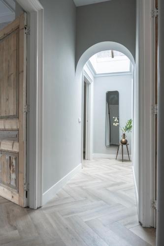 an open hallway with white walls and an archway at XXL loft with bath located Stadsvilla in Tilburg
