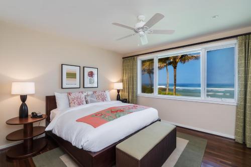 una camera da letto con un letto e una finestra con vista sull'oceano di 4-Bed Combination Villa 316-317 Turtle Bay a Kahuku