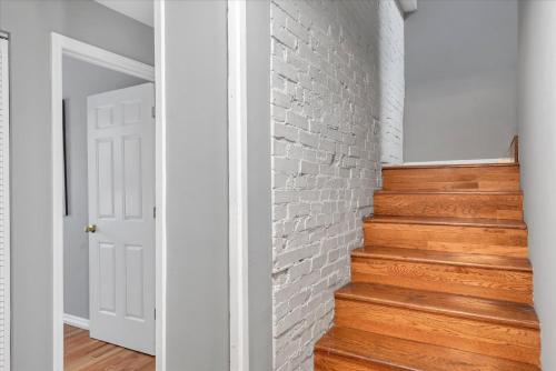 a white brick wall and stairs in a hallway at Amazing Recently Rehabbed STL Unit in Prime Soulard Location 713a in Soulard