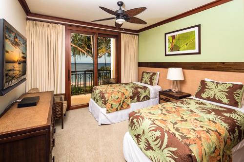 カポレイにあるBeach Tower 209 at Ko Olinaのベッド2台とバルコニー付きのホテルの部屋