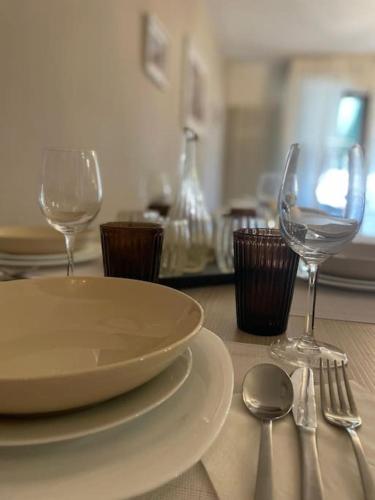 a table with a plate and two wine glasses at Appartamento Venice Excelsior in Favaro Veneto