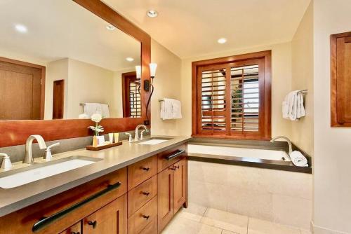 a bathroom with two sinks and a large mirror at Ocean Tower 503 at Ko Olina in Kapolei