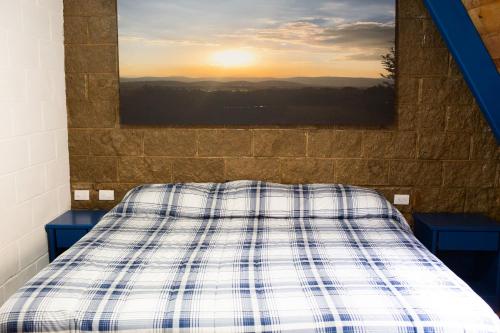 a bed with a plaid comforter in a room at Cabañas Bungalos las Alazanas in San Antonio de las Alzanas
