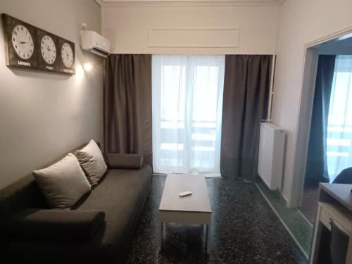 Thissio Hideaway Suite في أثينا: غرفة معيشة مع أريكة وطاولة قهوة