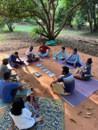a group of people sitting on the ground playing a game at Art Forest in Puducherry
