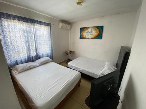 a small room with two beds and a television at Santa Rosa 4Rest in Monterrey