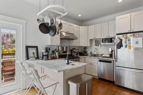 a kitchen with white cabinets and stainless steel appliances at Spacious SF Haven - Cozy Bedrooms & Modern Kitchen in San Francisco