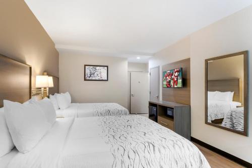 a hotel room with two beds and a mirror at Red Roof Inn PLUS Jamaica, NY - JFK Airport in Jamaica