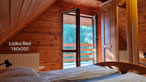 a bedroom with a bed and a large window at Trasą S7 w 2h z Warszawy i Gdanska, Jadamowo 16 nad jeziorem Mielno in Olsztynek