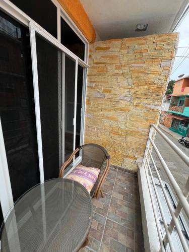 a glass table and a chair on a balcony at Zihua 360 in Zihuatanejo